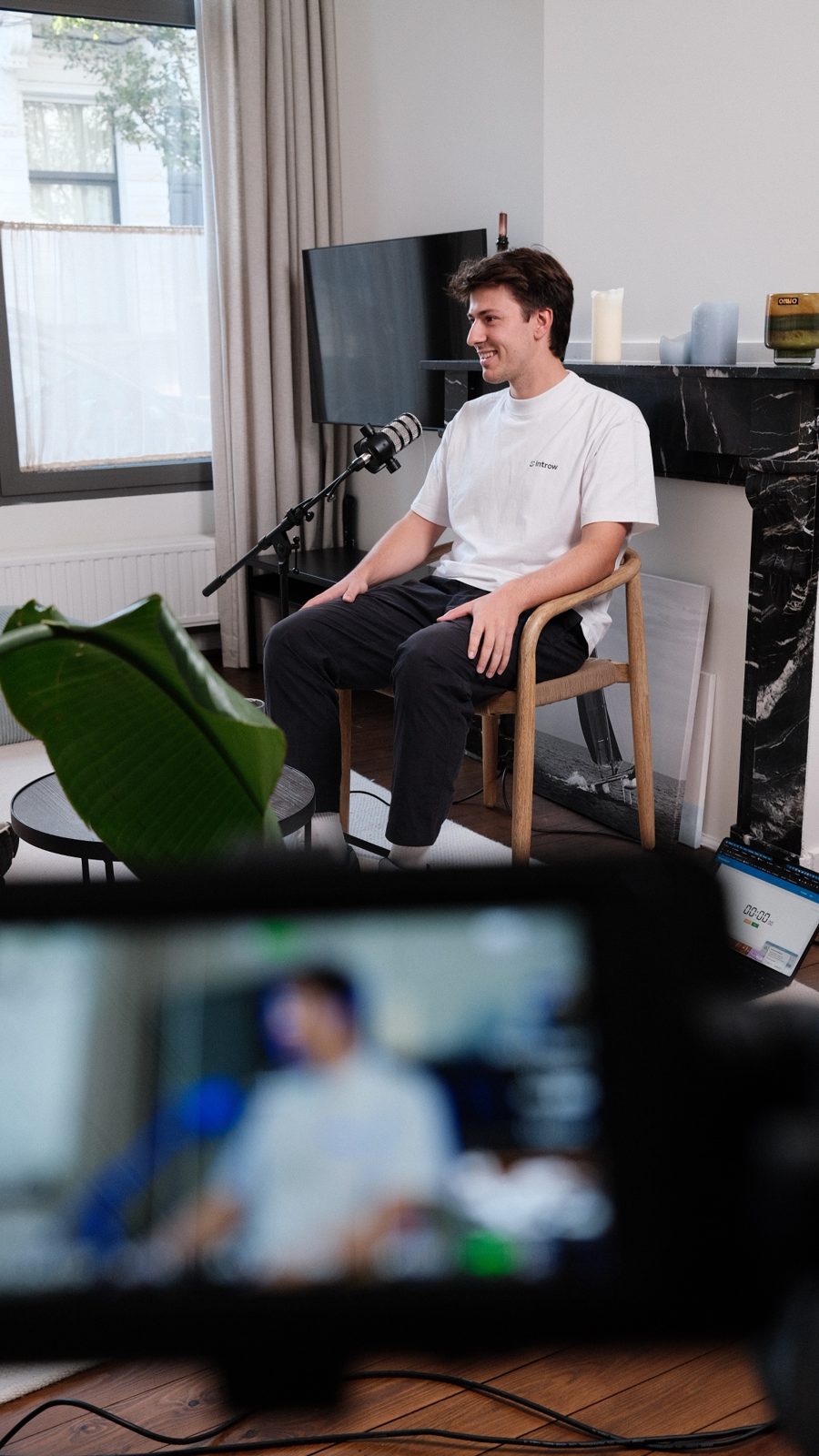 Andreas Geamanu smiling during the interview, with the camera monitor in the foreground