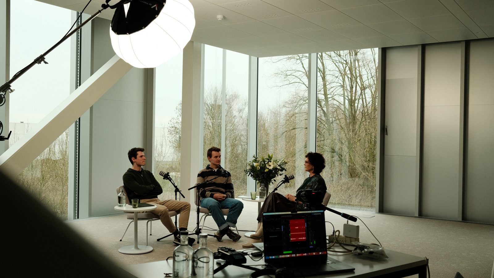 The recording set with Els Paesmans and the two hosts in a bright office space